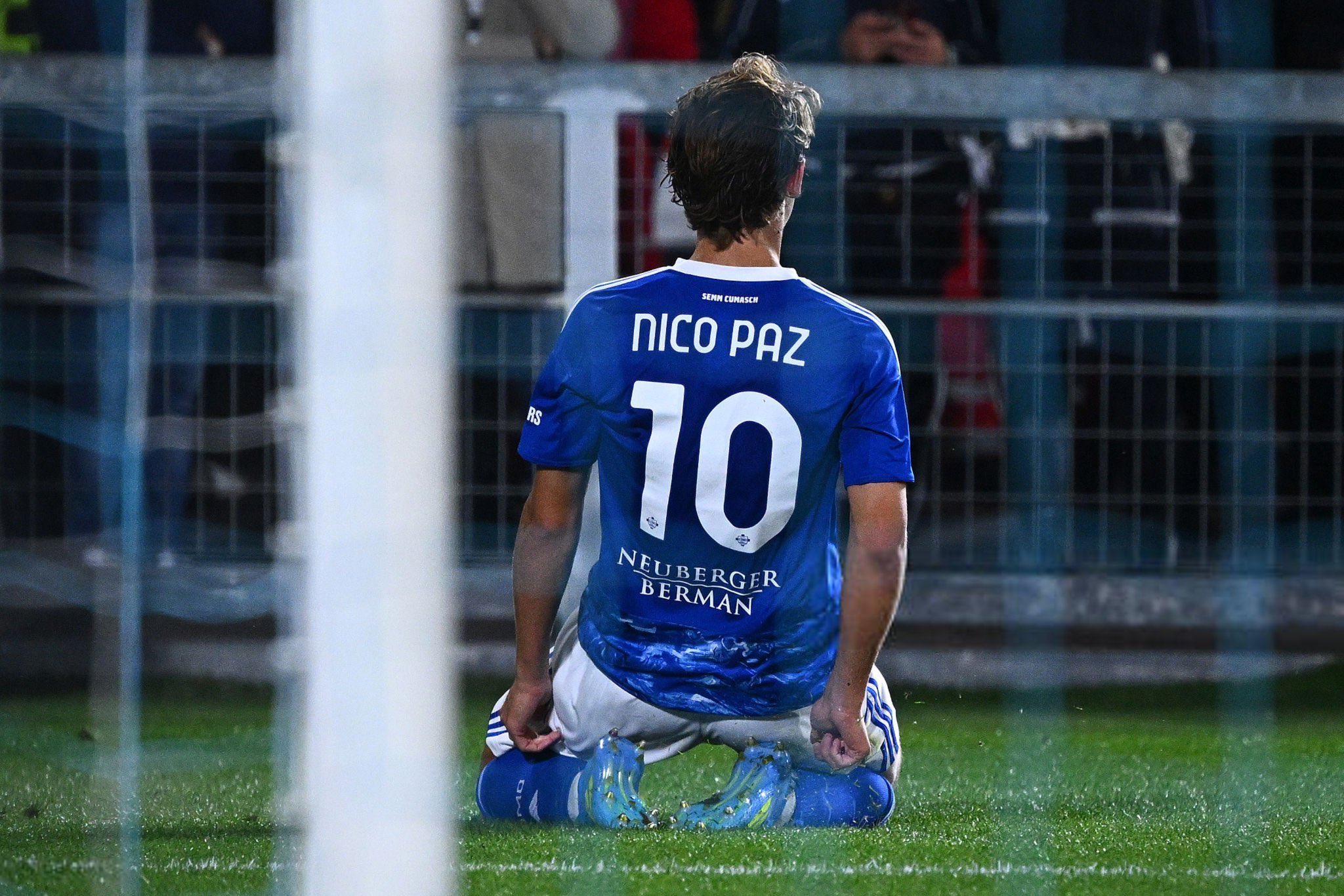 Nico Paz kneeling after scoring Como's second goal — Stadio Sinigaglia